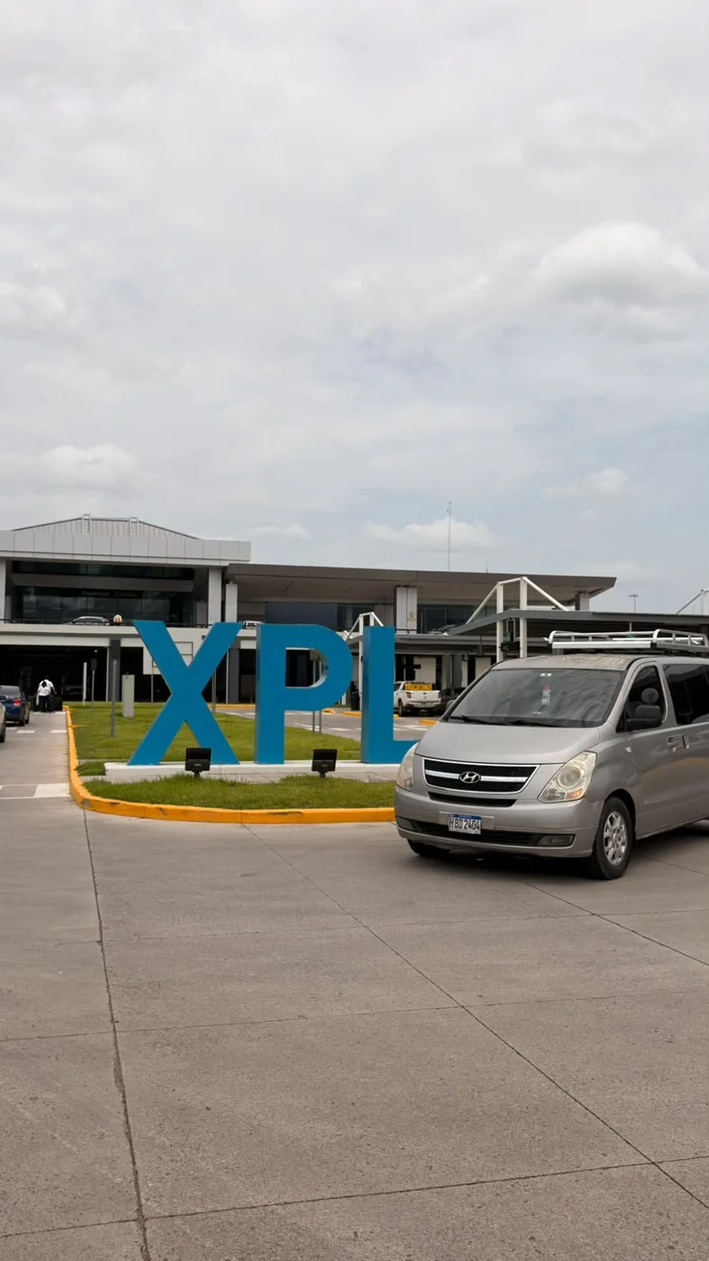 Microbús Travel VIP junto al letrero XPL